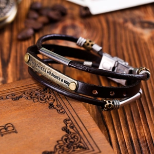 Detail of vintage multilayer leather bracelet with stainless steel clasp on wood background
