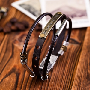 Detail of vintage multilayer leather bracelet with brass plate and motivational engraving