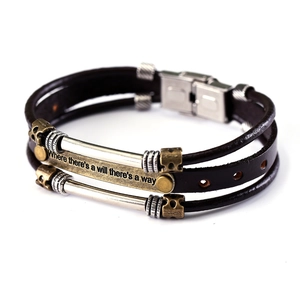 Detail of multi-layer leather bracelet with engraved Where there's a will motto metal plate