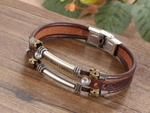 Detail of multi-layer leather bracelet with crown bead and engraved stainless steel bar