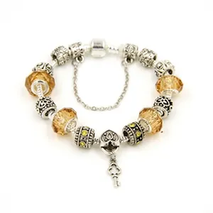 Detail of silver charm bracelet with yellow glass beads and heart key pendants on white back