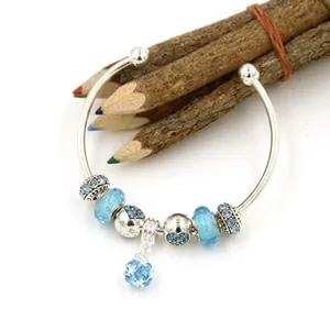 Detail of silver-plated DIY charm bracelet featuring blue glass beads and star pendant
