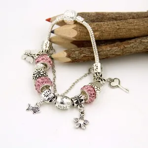 Close-up of pink crystal beads and flower charms on a silver snake chain bracelet