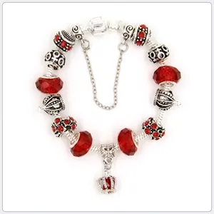 Detail view of Pandora-style charm bracelet with red crystals and crown pendant charms