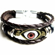Detail of vintage multilayer braided leather bracelet with central evil eye charm design