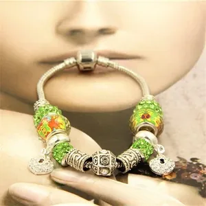 Détail du bracelet à chaîne serpent avec perles vertes et pendentif en cœur