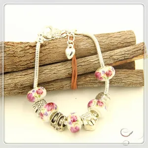 Detail of silver-plated charm bracelet with ceramic beads and MOM heart pendant