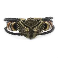 Detail of a punk multi-layer leather bracelet with bronze revolvers and wings shield