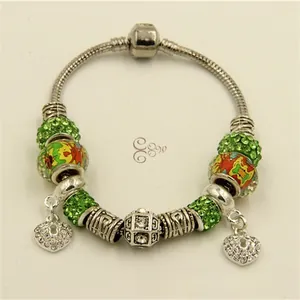 Détail d'un bracelet à perles avec cristaux verts et pendentifs cœur sur chaîne argent