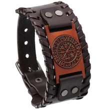 Close-up of vintage leather bracelet with Norse runes and compass totem plaque