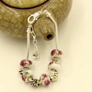 Silver snake chain bracelet with floral ceramic beads and Dog Mom paw print charm