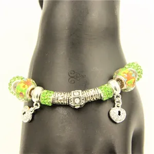 Vue détaillée d'un bracelet de perles en cristal vert avec pendentifs cœur en argent poli