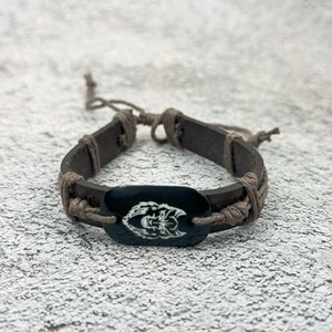 Adjustable woven leather bracelet featuring a vintage resin wolf head charm with a cord closure