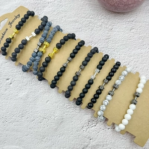Macro detail of dumbbell themed beaded bracelets with volcanic rock and marble stones