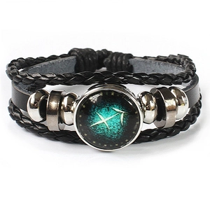 Detailed macro view of multilayer leather bracelet featuring Sagittarius zodiac glass cabochon