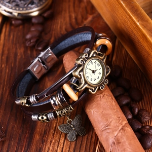 Bracelet montre vintage multicouche en cuir marron avec pendentif papillon sur bois sombre