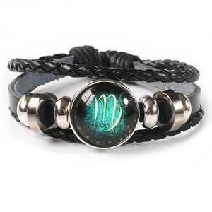 Detailed close-up of multilayer braided leather bracelet with Virgo zodiac glass charm