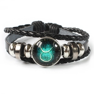 Macro shot of Taurus constellation glass dome on multi-layer braided leather bracelet