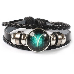 Detail of multi-layer Aries zodiac leather bracelet with green glass star dome charm