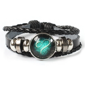 Detail of multi-layer leather bracelet featuring a luminous Leo zodiac sign glass bead