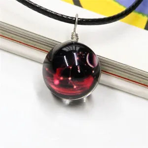 Cosmic nebula glass sphere pendant necklace with black woven cord and starry sky pattern