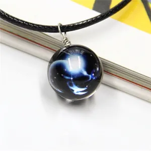 Detailed view of starry sky glass ball pendant with silver wire wrap and blue nebula motif