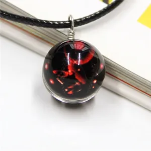 Macro shot of celestial glass globe pendant with red nebula nebula and black cord