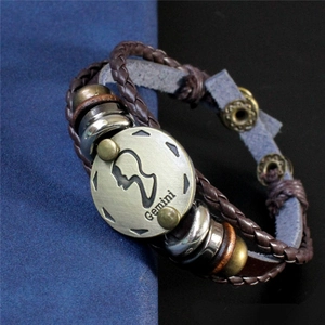 Détail du signe Gémeaux sur bracelet en cuir tressé avec fermoir en bronze antique