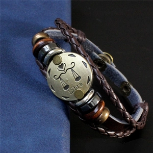 Gros plan du bracelet Balance en cuir tressé avec breloque en bronze et perles