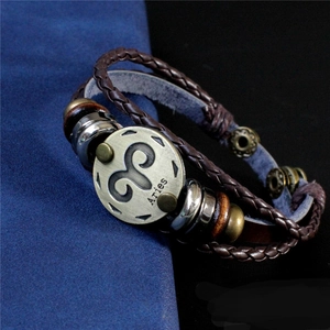 Détail du signe bélier gravé sur un bracelet multicouche en cuir marron de style punk