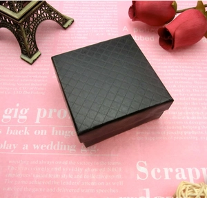 Detail einer schwarzen quadratischen Geschenkbox mit Rautenmuster für Schmuckstücke
