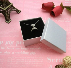 Detaillierte Ansicht von Herz-Anhänger-Halskette und Kronenring-Set in weißer Geschenkbox