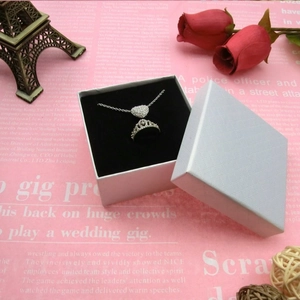 Silbernes Schmuckset mit Herz-Halskette und Kronenring in einer weißen Geschenkbox