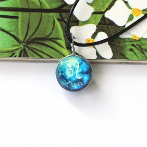 Detalle del colgante de bola de cristal galaxia azul con el signo zodiacal de Leo en cordón