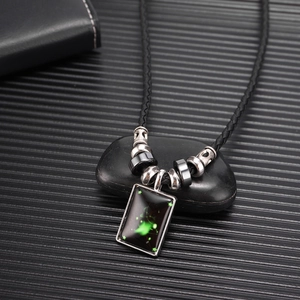 Collier pendentif constellation lumineux avec lueur verte sur cordon tressé noir