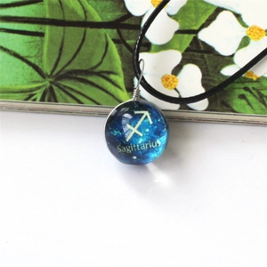 Detalle del colgante de bola de cristal Sagitario con diseño de cielo estrellado azul