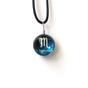 Detalle del collar de bola luminosa signo Escorpio con diseño de cielo estrellado azul