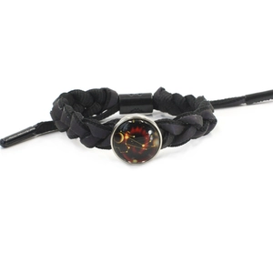 Braided black cord Leo zodiac bracelet featuring a glass cabochon constellation charm