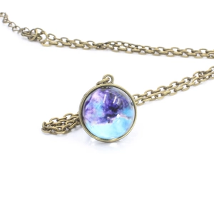 Detailed macro view of vintage bronze solar system necklace with purple nebula glass dome