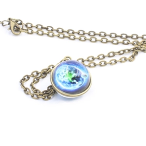 Macro detail of bronze solar system necklace with vintage earth glass dome pendant