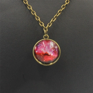 Close-up of bronze necklace with double-sided glass pendant showing pink nebula star patterns
