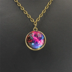 Macro detail of bronze galaxy necklace pendant with blue and purple nebula glass dome art