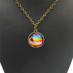 Detail of vintage bronze necklace with double-sided solar system nebula glass ball