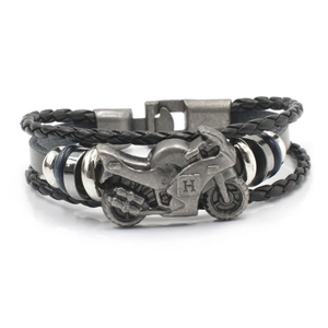 Detail of multi-layer leather bracelet featuring a vintage silver motorcycle charm with H engraving