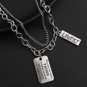 Detail of silver dual-layer necklace with engraved rectangular dog tags for men
