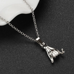 Detailed close-up of a silver Shaka hand gesture pendant on a thin link chain necklace
