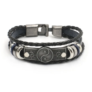 Detail van meerlaagse gevlochten lederen armband met yin yang bedel en kralen