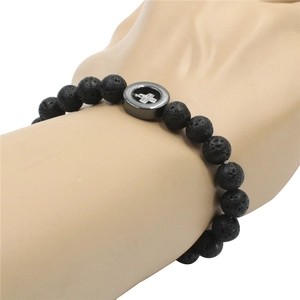 Nahaufnahme des Lavastein-Armbands mit einem hohlen Metallkreuz auf einem Display-Arm