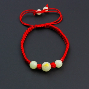 Handmade red cord bracelet with luminous beads featuring a golden Chinese zodiac rat pattern