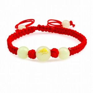 Handmade red string zodiac bracelet with glowing beads and golden rat motif on white background